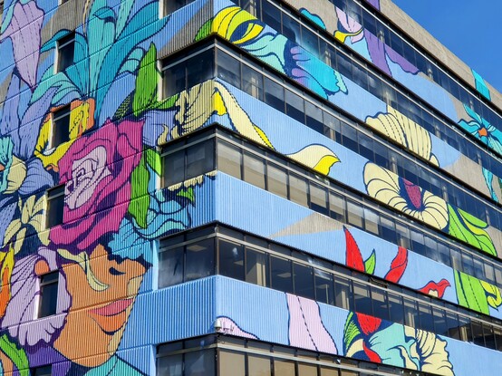 Corner view of the same art, showing the painting extending down the side of the building 