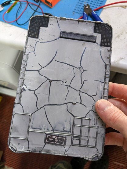A back off a kindle keyboard that looks like a cracked dried out river bed. 