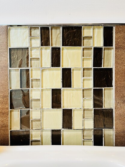 5 rows of bathroom tiles in creams and browns, with the bottom 4 rows following a consistent pattern, while the top row uses all the right tiles but in completely the wrong order