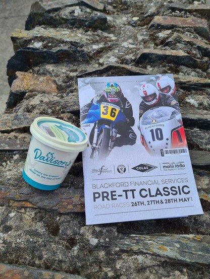 A tub of Davisons ice cream with a programme for the 2023 pre TT classic motorbike races