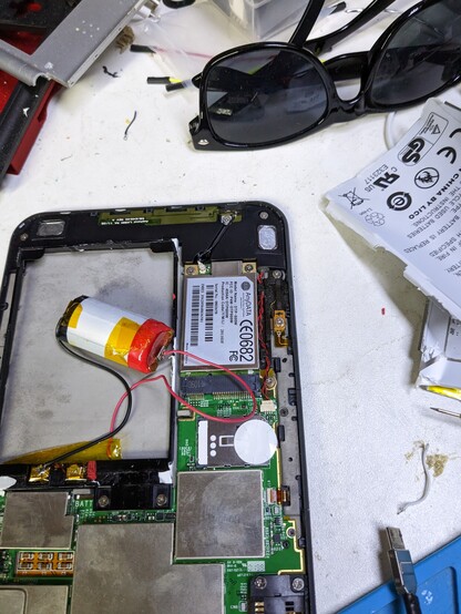 Kindle keyboard with the back removed with a e cig lipo attached to the old battery PCB