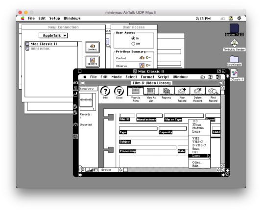 A screenshot of Mini VMac showing the desktop, a couple of Timbuktu windows, along with the desktop of another computer via AppleTalk (my Mac Classic II showing FileMaker Pro 4.0's example Film & Video Library file. The "Format" field is highlighted showing types such as 110, 35mm, VHS, VHS-C, 8mm, Hi8, and Laser.