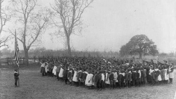 Photo of 10,000 formerly enslaved people standing before the flag on the first Memorial Day.