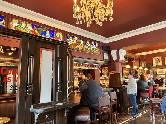 Inside The Flowing Tide, red walls, dark wood and stained glass above the bar