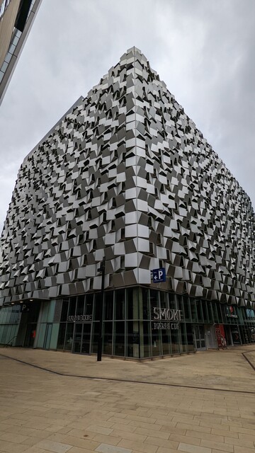 A large cubic building with irregular faceted silver grey cladding looks like a Borg Cube from Star Trek. It's actually a multi storey car park. 