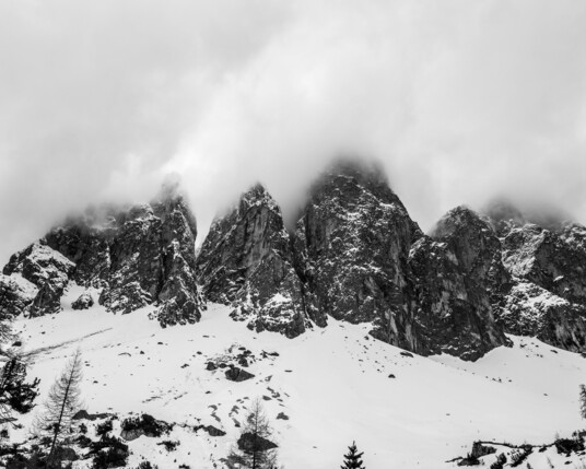 View onto the Geissler peaks fom below as they are covered under snow and the peaks are in the clouds.