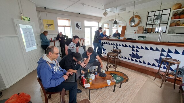 Im Kaminzimmer sind verschiedene Leute in ihren Laptops vertieft.