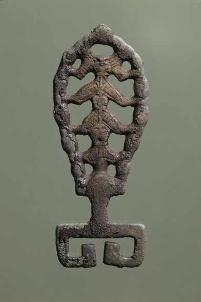 Llave metálica con forma de hoja. Su interior es hueco, con una espina con cuatro barras metálicas que la conectan a ambos lados.