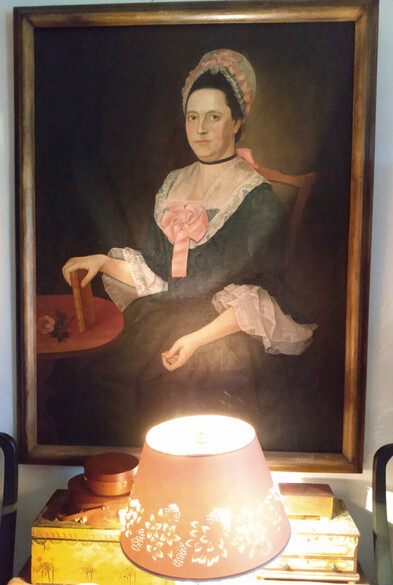 Hannah Choate Lathrop, in a colonial period green dress with big lace sleeve flounces, lace on a fichu, and a cap with lace and pink ribbon. A big pink rosette flower made of ribbon in the center of her stomacher. 

More details: https://www.historicnewengland.org/explore/collections-access/gusn/2156