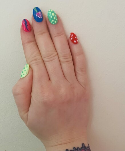 Nail art on right hand. Starting at the thumb bright yellow with green spots, bright pink background with pink/blue/orange tentacles, bright blue background with purple and white spotty and green toadstool, bright green with bright yellow spots, and lastly red with white spots.