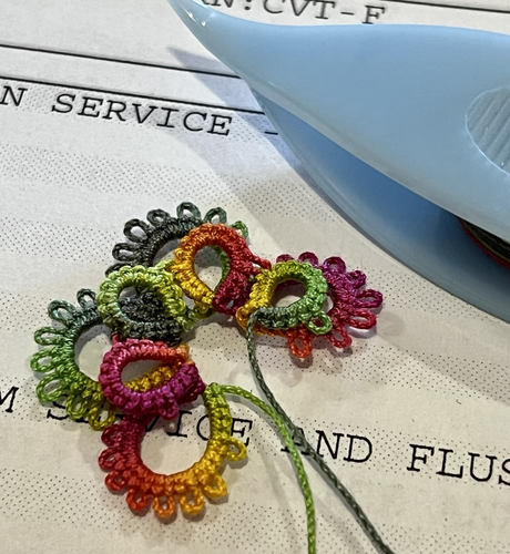 Tatting motif in progress with a tatting shuttle.