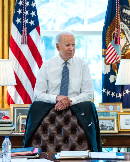 President Joe Biden standing behind his desk in Oval Office 