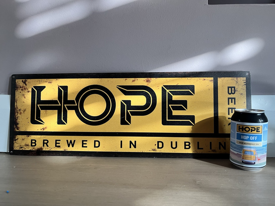 A can of Hope Hop Off Non-Alc IPA in front of a Hope Beer sign 