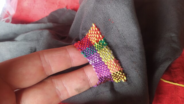 A small colourful darned pocket with two of my fingertips in it! 