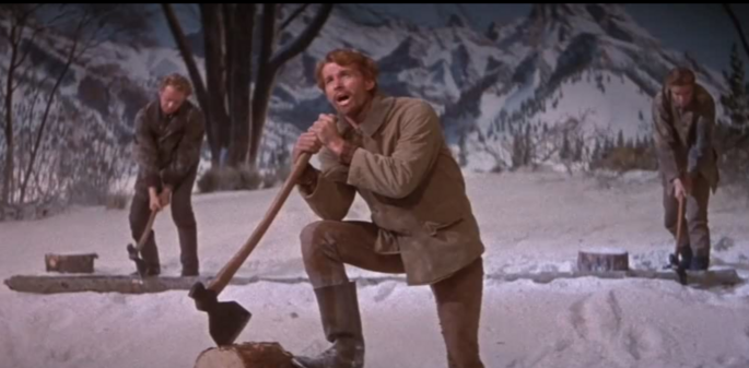 Three young white men with red hair (brothers) are outside chopping wood in wintertime. One of them is singing.