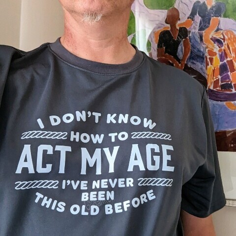 Person trägt ein T-shirt mit dem Aufdruck "I don't know how to act my age. I've never been this old before."