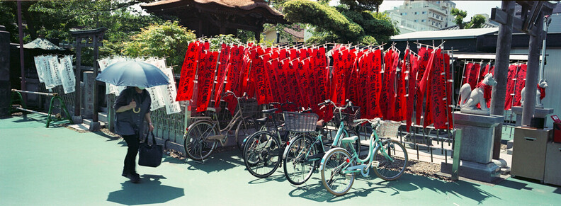 A lady with a large umbrella on a hot day in Tokyo, with Fujifilm TX-1 and Fuji Reala 100.