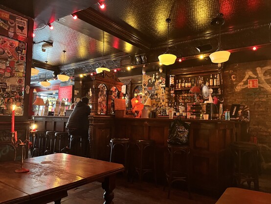 Inside Cassidys: dark wood, drippy red candles, red lights, long bar, some graffiti on the brick wall