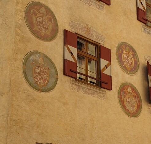 Fenster einer alten Burg mit 4 Wappen rundherum