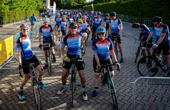 Cyclists on a previous Climate Classic ride, wearing warming stripes on their jerseys.