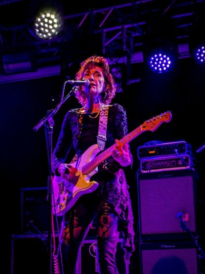 Lesley Woods playing guitar on stage 