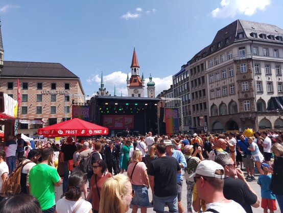 Lots of people at the #Marienplatz in Munich at the CSD. In the background  is a stage and the old townhall.