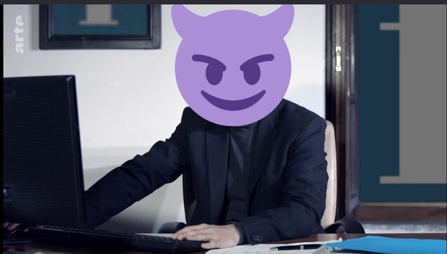 Un personnage avec une veste de costume noire et t-shirt noir dans un bureau devant un ordinateur. Sa tête est remplacée par un emoji diable qui sourit 😈 cela fait penser qu'il est manipulateur.