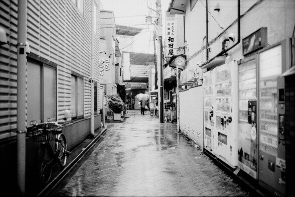 A man with an umbrella on a rainy evening in Tokyo, with Leica M6 and Fujifilm Acros II.