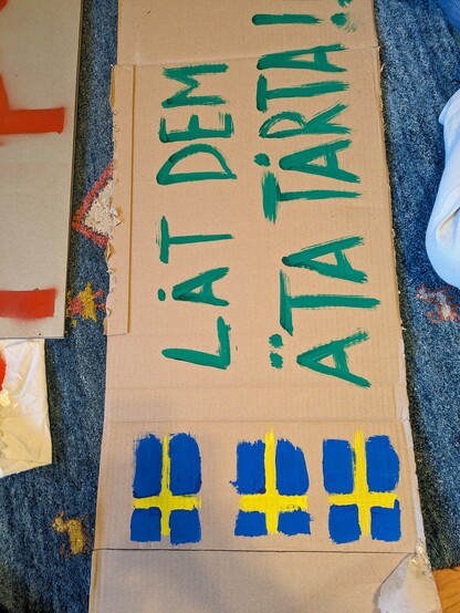 Poster with Swedish flags and slogan "låt dem äta tarta!"