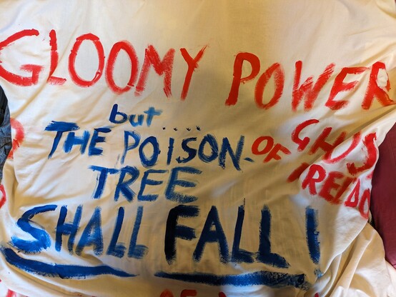Banner reading "gloomy power but the poison tree shall fall!"