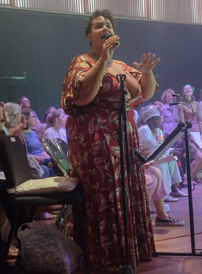 adrienne maree brown in long dress, looking radiant. Behind her to  the right, Surinamese-Dutch Winti priestess Marian Markelo.