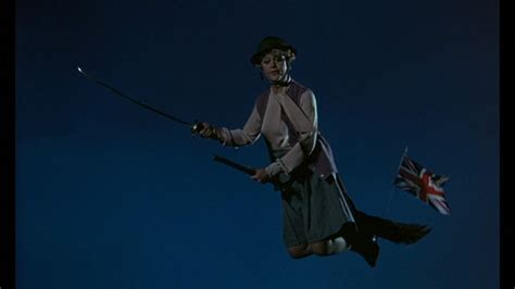 A middle-aged woman holding a sword is flying on a broomstick bearing the British flag. She is a witch who has learned witchcraft in order to help fight Nazis, and she is on her way to assist the knights in armor she has mobilized to help repel a Nazi invasion.