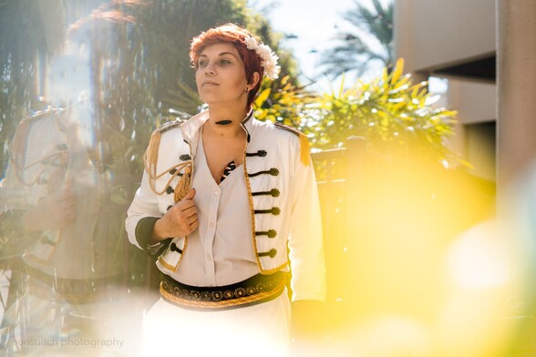 Portrait photo of me cosplaying Kiriona Gaia. There's a soft out of focus effect on the foreground. I'm looking to the viewers left and holding the opening of my jacket with my left hand