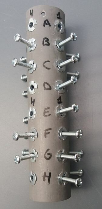 Le même tube de PVC, avec des vis mises dans certaines chevilles.