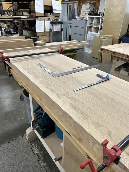 A long countertop getting laid out for cutting into pieces. 