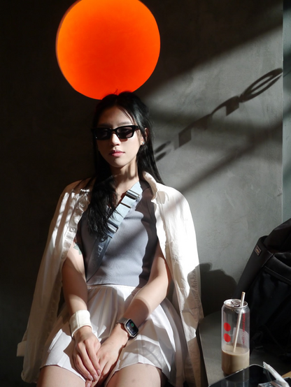 Girl sitting against Sun-lit wall