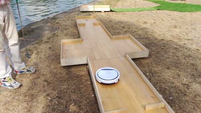 Minigolf Hindernis mit weißem Staubsaugerrobober.