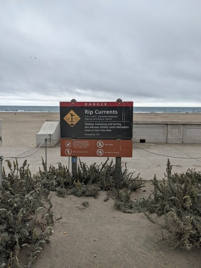 A sign on a beach explaining the dangers of rip currents