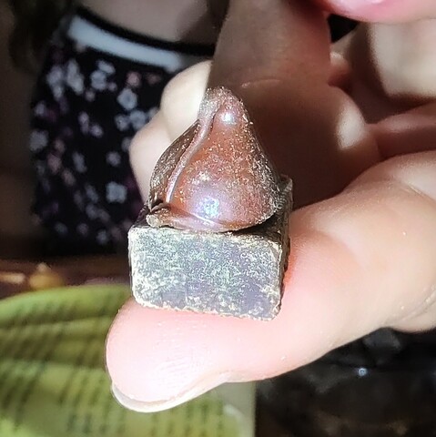Photo of a child's finger balancing a chocolate cube topped with a chocolate chip