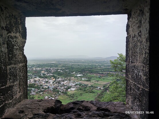 The view of a city from a stone window.