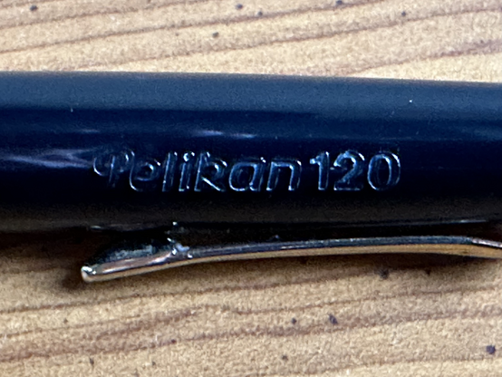 A close-up of the engraving on the fountain pen reading “Pelikan 120.”