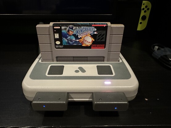 Super Nt console with Ken Griffey Jr cartridge and two wireless controller receivers plugged in.
