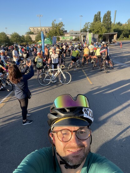 A selfie of me at the start line of the Seattle to Portland bike ride. The start line and many many bikes are in the background. 