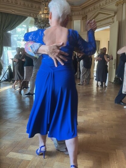 A couple dance Argentine Tango in close embrace in the grand ballroom setting at the Argentine Ambassador's Residence in London.