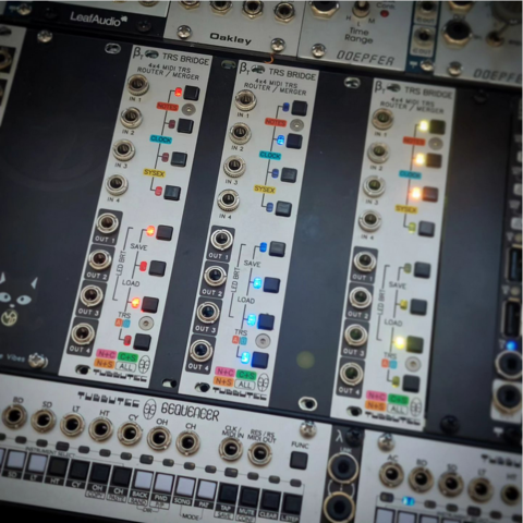 Three TRS-Bridge eurorack modules in a rack. One currently routing notes in red, one clock in blue and one sysex in yellow