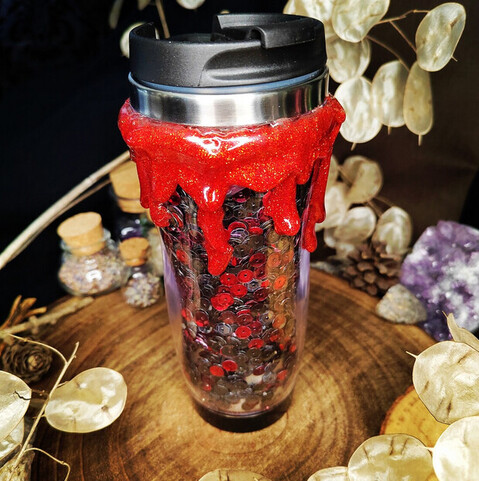 Ein dekorativer Trinkbecher mit Deckel mit "Blut" und Pailetten.
Foto aus dem Shop LeafWork Design