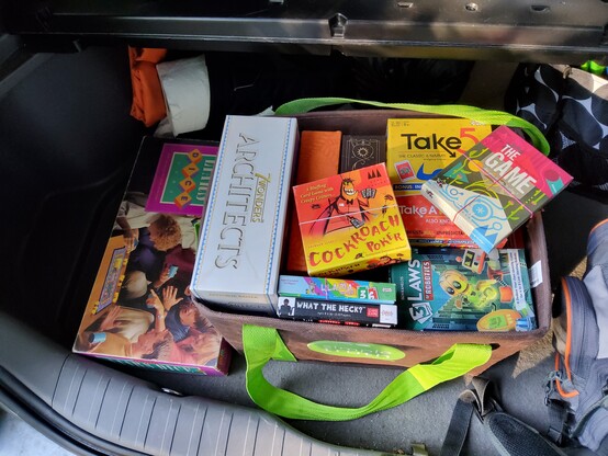 Picture of a bag containing various board games including those listed in the post above. Liar's Dice, the Milton Bradley edition, sits alongside the bad. 