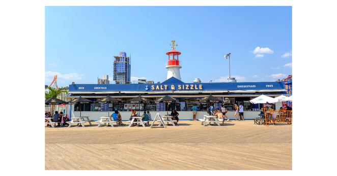 A "Salt & Sizzle" booth on Coney Island beach with snacks