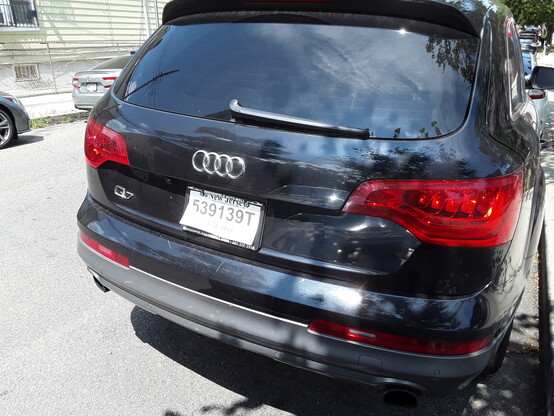 Rear view of a black SUV with a fake paper license plate parked near the 103rd precinct in Queens, NYC. The expiration date (January 14, 2023) is not clear in this shot.