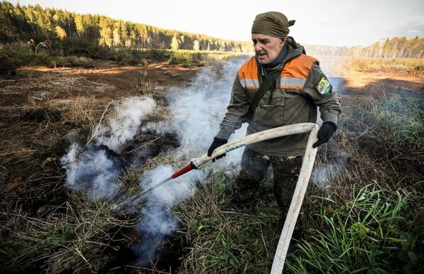 A volunteer fights ‘zombie’ peat fires in Siberia in 2020, a year when an estimated 100,000 square miles of forest, grassland and peatland burned, according to an International Association of Wildland Fire analysis. Alexander Nemenov / AFP via Getty Images
